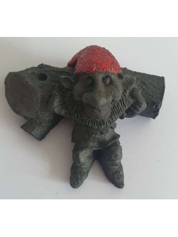 Auf einem Baumstamm liegender Gnom aus Harz.